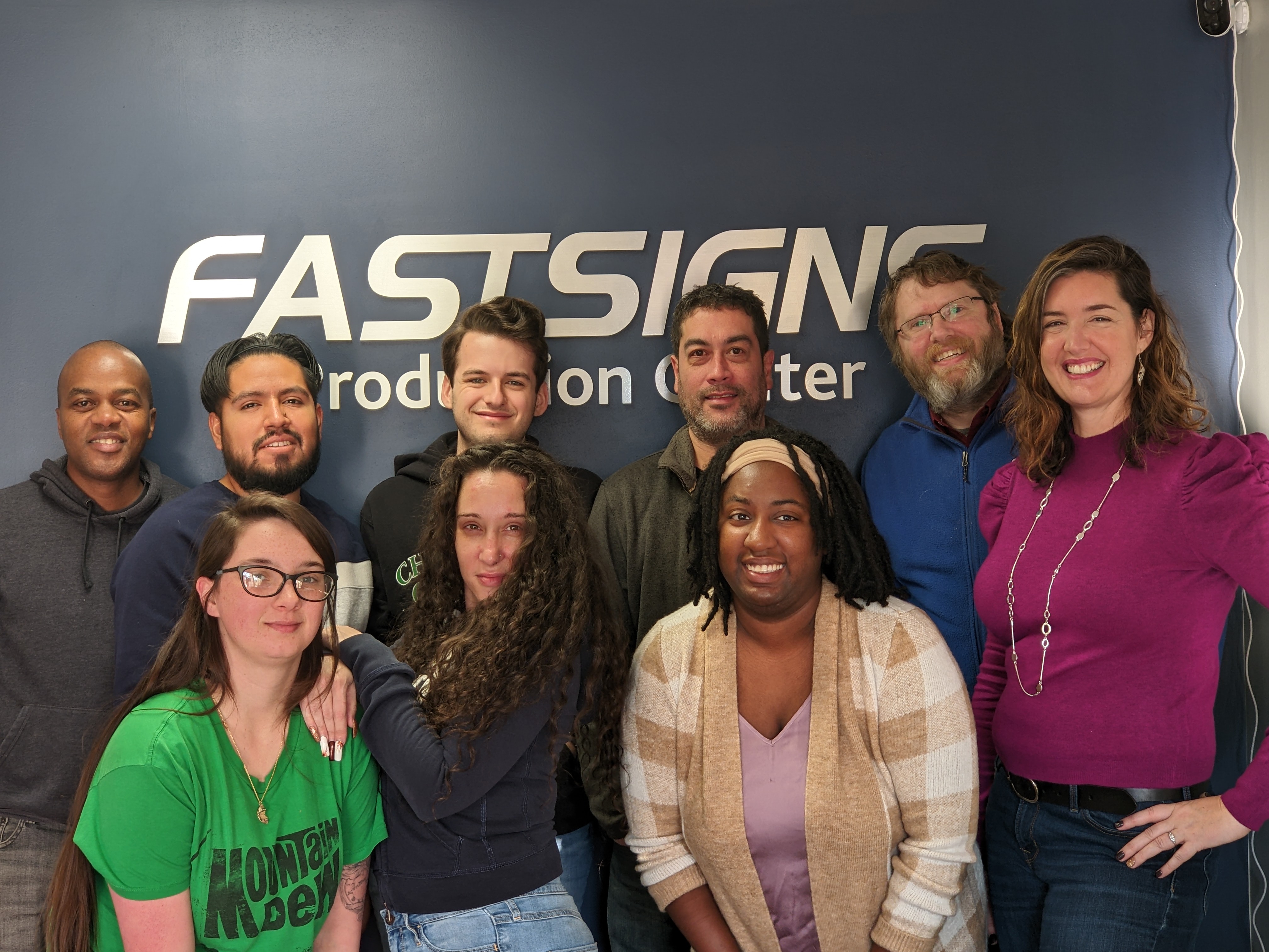 The team at FASTSIGNS of Springfield VA pose outside of their storefront